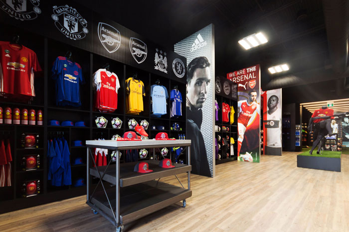 In2Sports Retail Store by Unfold Creative Studio - Fan Wear Area organized by team to make it easier for fans