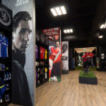 In2Sports Retail Store by Unfold Creative Studio - Custom lightbox graphics divide the space into zones pertaining to leagues, and creates a dynamic experience when you first walk into the store.